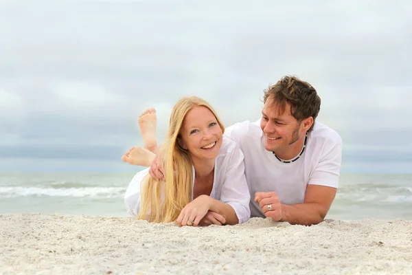 Casal feliz Relaxando na praia junto ao oceano — Fotografia de Stock