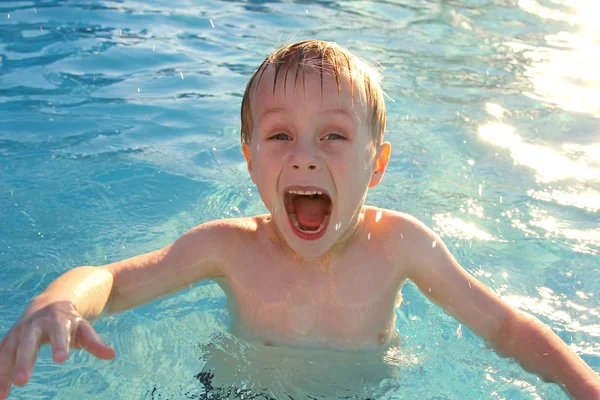 Niño muy emocionado nadando en la piscina —  Fotos de Stock