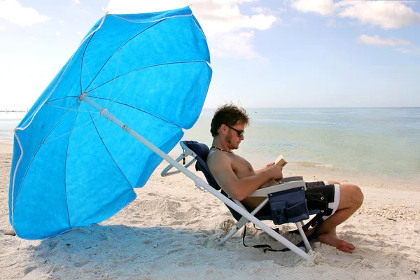 Man Reading by Ocean Under Guarda-chuva da praia — Fotografia de Stock