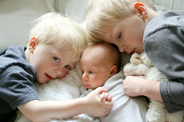 Grote broers knuffelen Pasgeboren Baby zus — Stockfoto