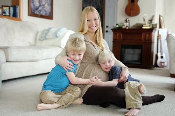 Feliz madre embarazada y sus dos hijos pequeños en casa — Foto de Stock