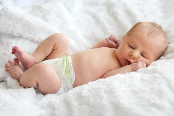 Новорожденный ляжет на пушистое белое одеяло — стоковое фото