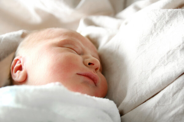 Sleeping Newborn Baby in White Blankets