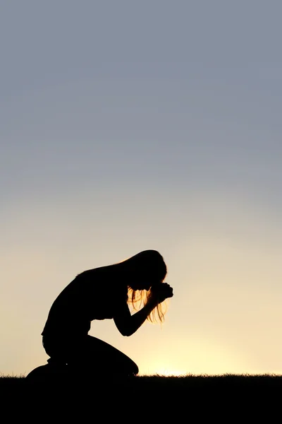 Mulher sentada na silhueta de oração — Fotografia de Stock