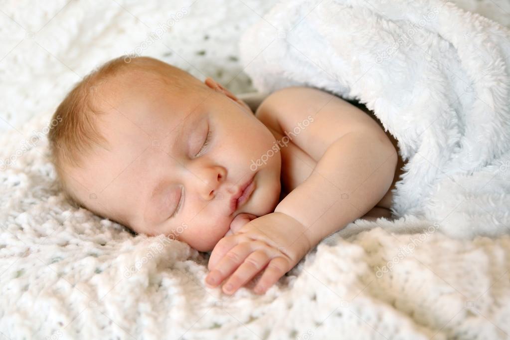 Sweet Newborn Infant Girl Sleeping in White Blankets