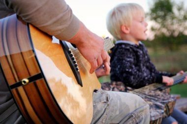 Baba ve oğul gitar çalıyor ve şarkı dışında