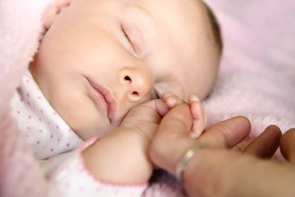 Dormir niña sosteniendo la mano de la madre — Foto de Stock