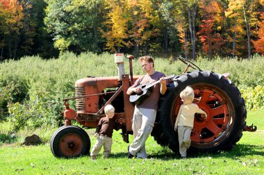 Baba ve oğlu eski çiftlik traktör tarafından gitar çalmak