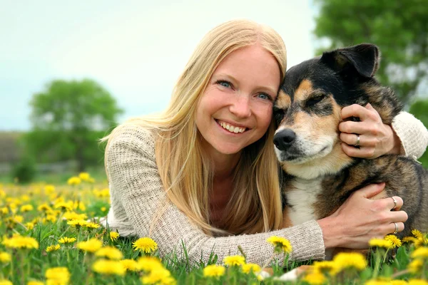 Счастливая женщина и домашние собаки расслабляются и обнимаются снаружи — стоковое фото