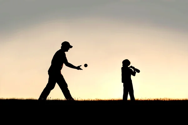 Silueta de padre e hijo pequeño jugando béisbol fuera —  Fotos de Stock