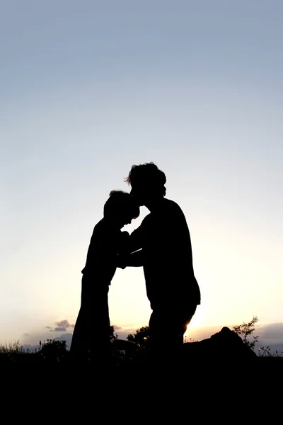 Silhueta de Pai Beijando Jovem na testa — Fotografia de Stock