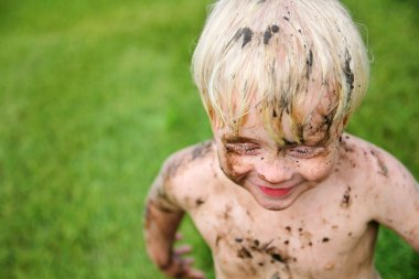 Happy Little Child Covered in Dirt PLaying Outside clipart