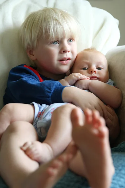 Großer Bruder kuschelt kleine Schwester — Stockfoto