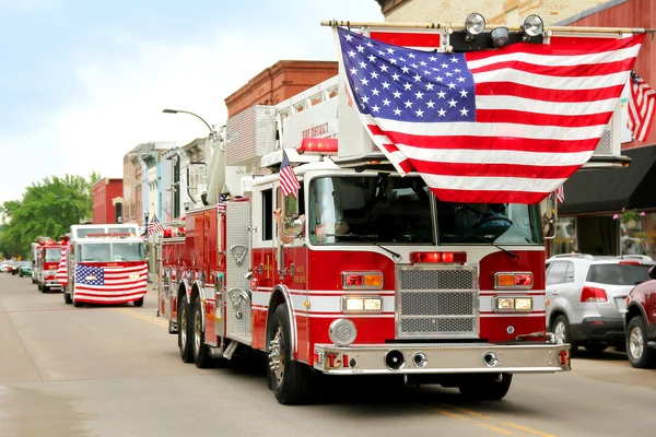 Пожежні автомобілі з американськими прапорами на маленьке місто параді — стокове фото