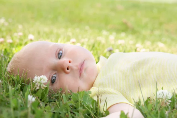 Vackra nyfödd baby flicka om i gräset utanför — Stockfoto