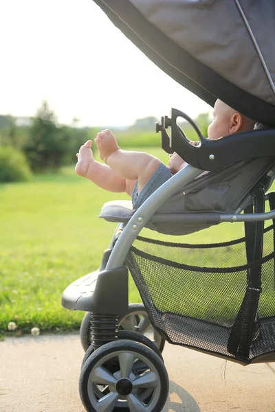 Ноги новорожденного и ноги висят на коляске — стоковое фото