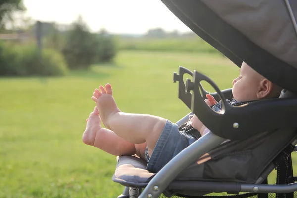 Pasgeboren Baby benen en voeten opknoping uit wandelwagen — Stockfoto