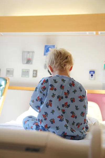 Criança sentada na cama do hospital — Fotografia de Stock