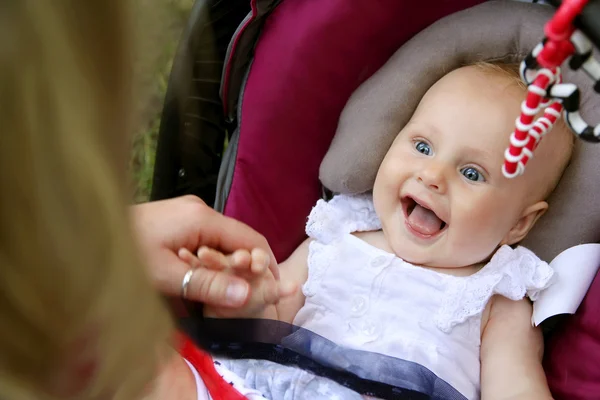 Смеющаяся новорожденная девочка в автомобильном кресле — стоковое фото