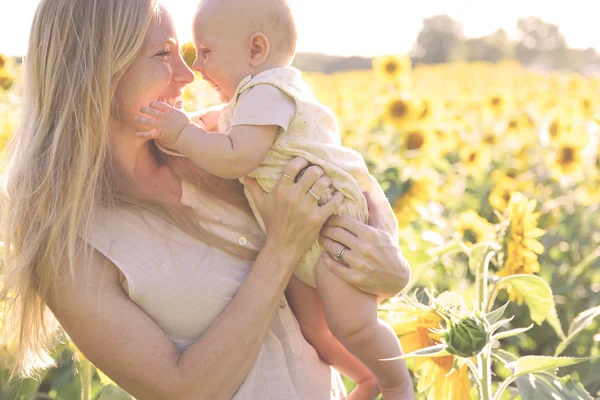 Šťastná matka a dcera Baby ve slunečnicovém poli — Stock fotografie