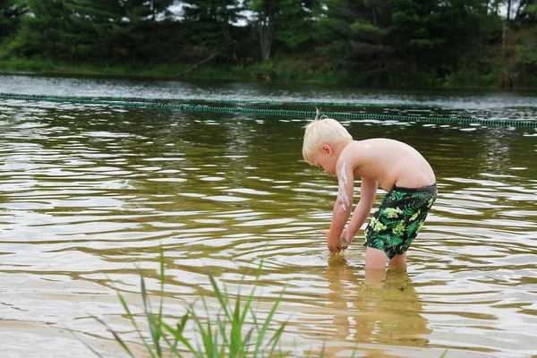 Jong kind spelen buiten in Lake — Stockfoto
