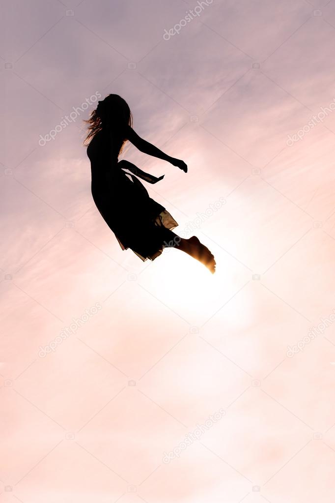 Silhouette of Woman Flying through Sky