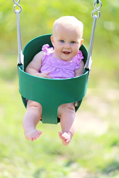 Oyun alanı sallanan mutlu bebek kız — Stok fotoğraf
