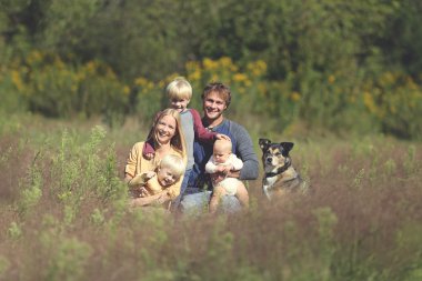 Mutlu aile 5 kişi ve köpek güneşli bahçe içinde