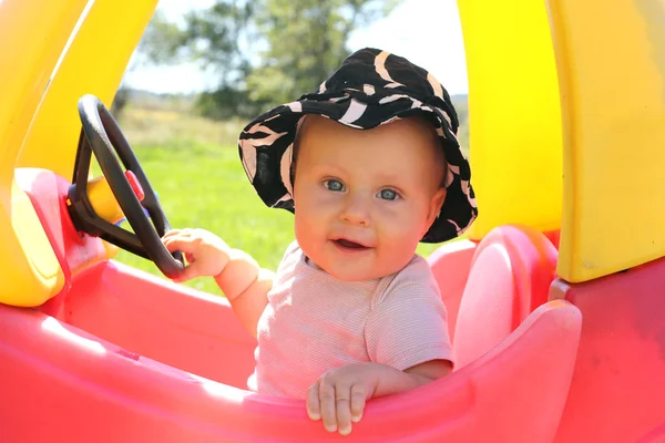 Schönes Baby spielt draußen in Spielzeugauto — Stockfoto