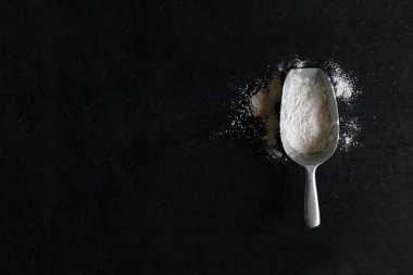 Vintage Measuring Scoop Spoon on Black Slate Background