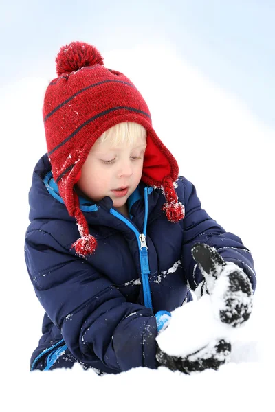 Kleines Kind spielt im Winter Schnee und macht Schneeball — Stockfoto