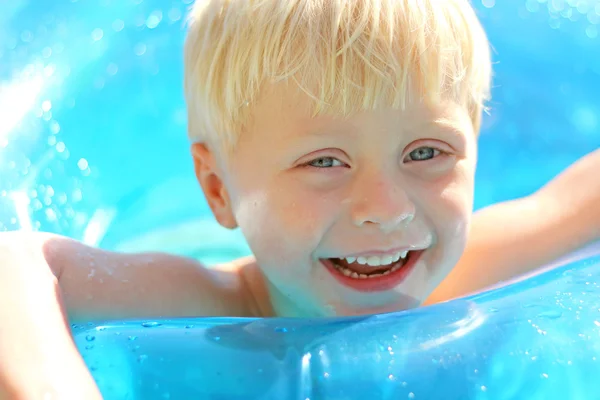 Entzückend lachendes blondes Kind spielt im Schwimmbad — Stockfoto