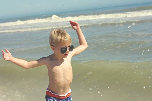 Criança feliz brincando no oceano — Fotografia de Stock