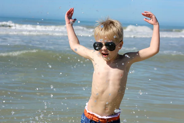 Criança feliz brincando no oceano — Fotografia de Stock