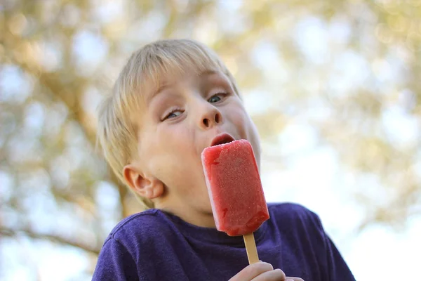 Молодой ребенок ест мороженое эскимо снаружи — стоковое фото