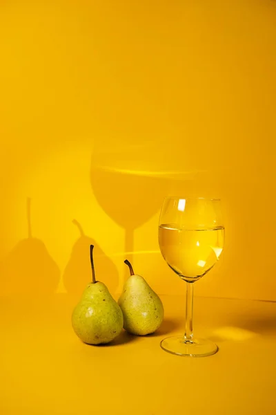 a glass of white wine close-up on a bright background and pears. advertising of elite alcoholic beverages. selective focus,copy space. for the blog of sommeliers and winemakers.restaurants advertising