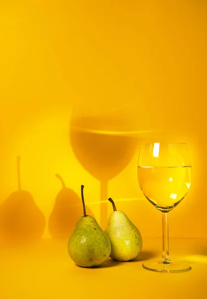 a glass of white wine close-up on a bright background and pears. advertising of elite alcoholic beverages. selective focus,copy space. for the blog of sommeliers and winemakers.restaurants advertising