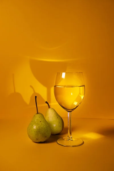 a glass of white wine close-up on a bright background and pears. advertising of elite alcoholic beverages. selective focus,copy space. for the blog of sommeliers and winemakers.restaurants advertising