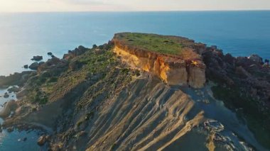 Drone 'un gün batımı manzarası kırsal, plaj, kayalar, deniz. Malta adası