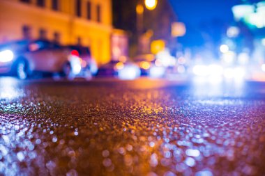 Şehirde sonbahar yağmurlu geceleri. Ata binen arabaların farları. 