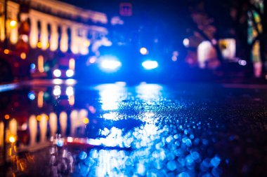 Şehirde sonbahar yağmurlu geceleri. Yaklaşan arabaların farları. 