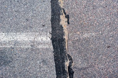 Yoldaki eski asfalt. Yatay beyaz bölme çizgisi. 