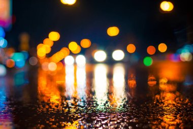 Şehirde yağmurlu bir gece. Farlar arabalara yaklaşıyor.. 