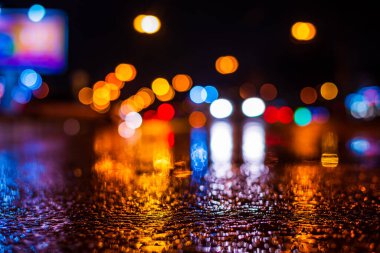 Şehirde yağmurlu bir gece. Farlar arabalara yaklaşıyor.. 