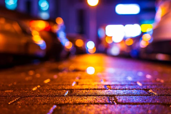 Rainy night. Parking mall with cars. Reflections of shop windows