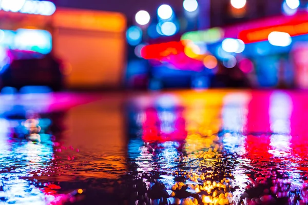 Rainy night. Parking mall. Reflections of shop windows