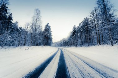Bir kış günü kar yağışı, karla kaplı köy yolu. 