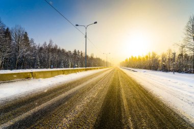 Açık bir kış sabahında gün doğumu, karda boş otoyollar. 