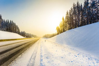 Açık bir kış sabahında gün doğumu, karda boş otoyollar.  