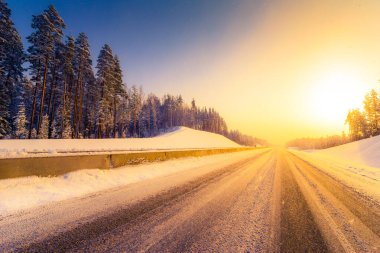 Açık bir kış sabahında gün doğumu, karda boş otoyollar.  